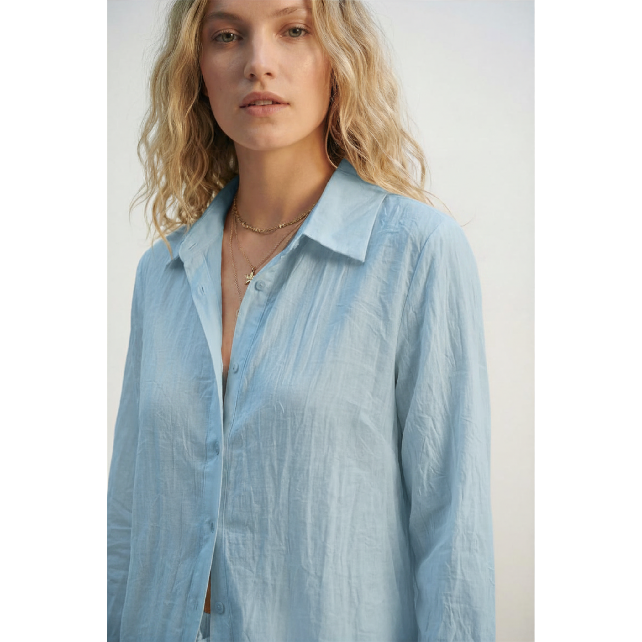 Woman wearing a light blue shirt against a plain background